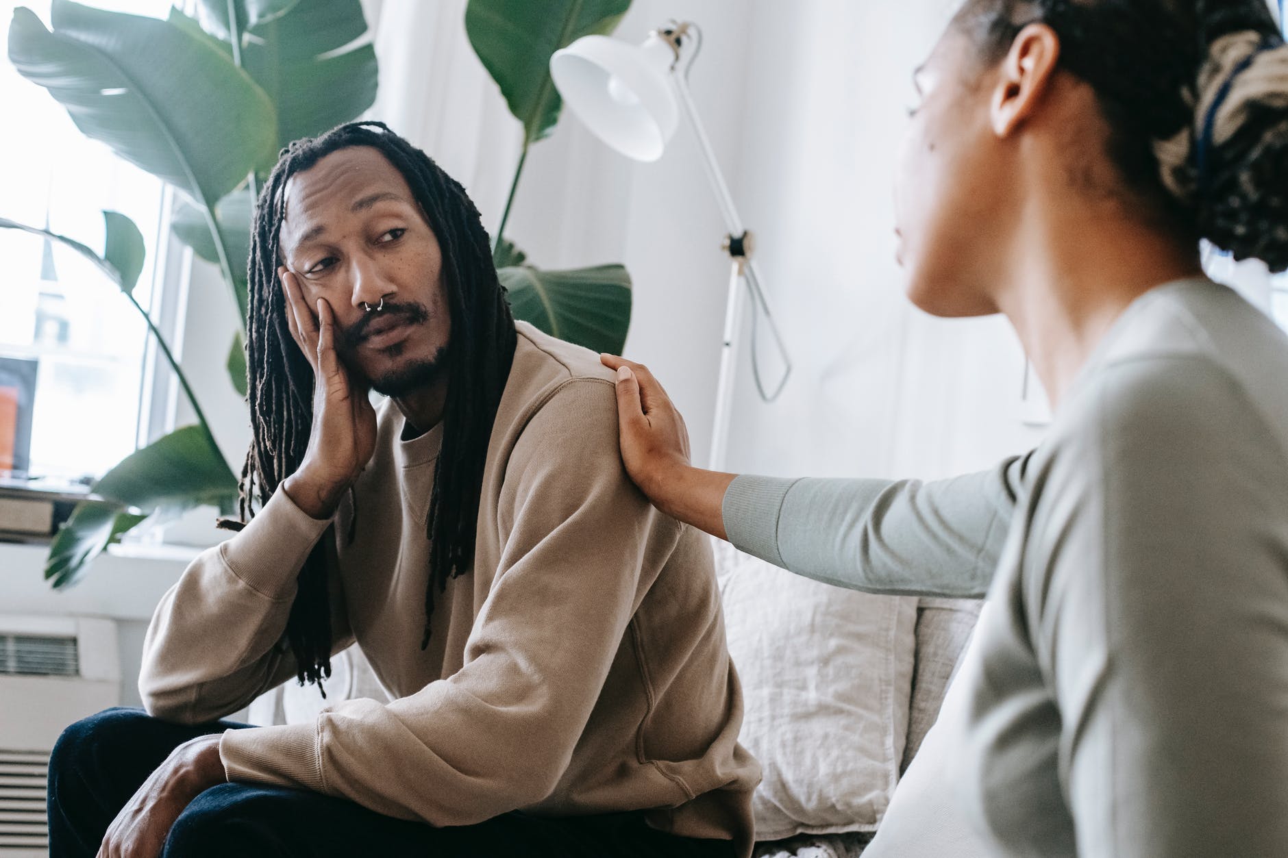 ethnic psychologist touching black depressed clients shoulder