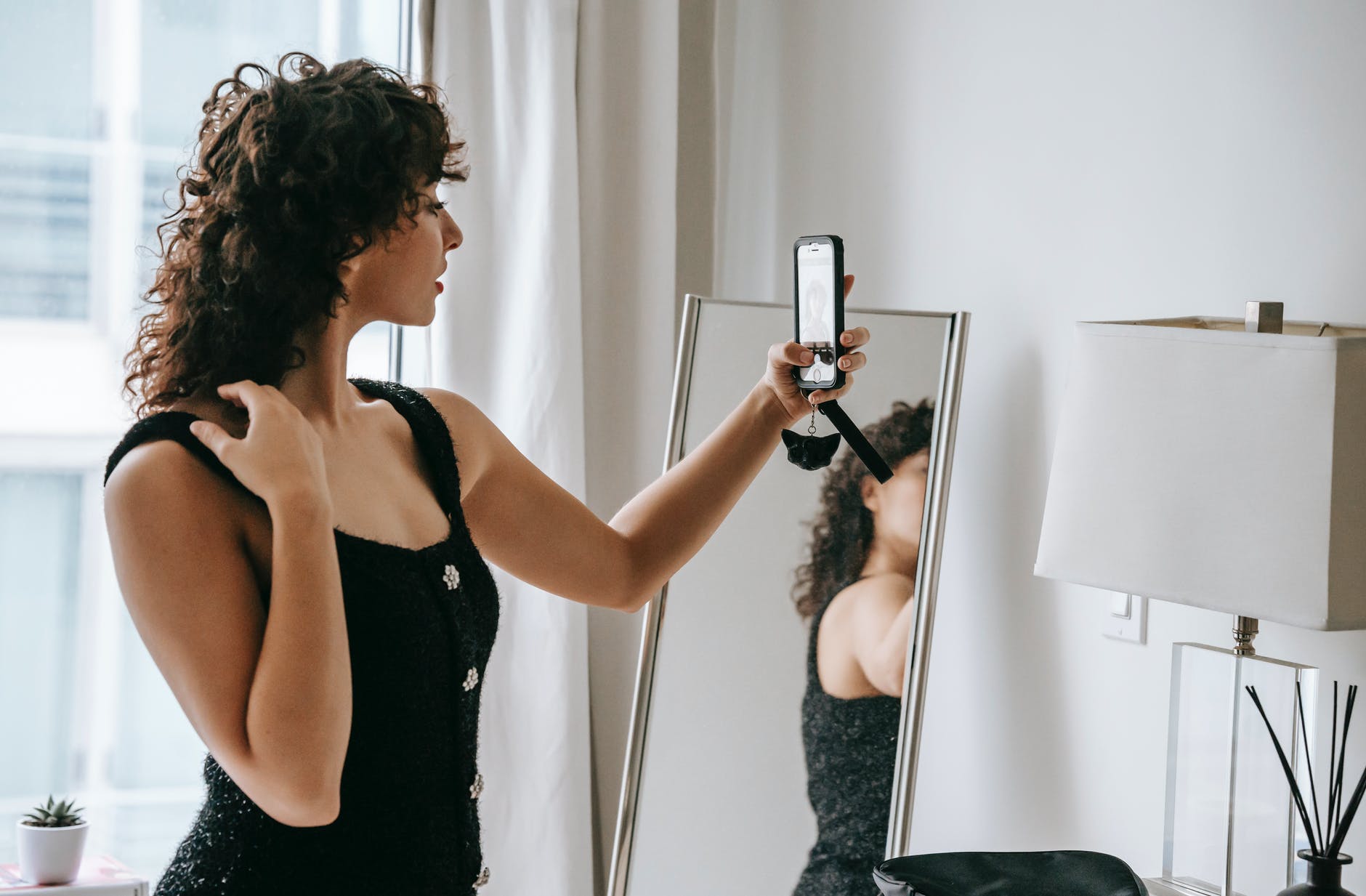 beautiful woman taking selfie against mirror