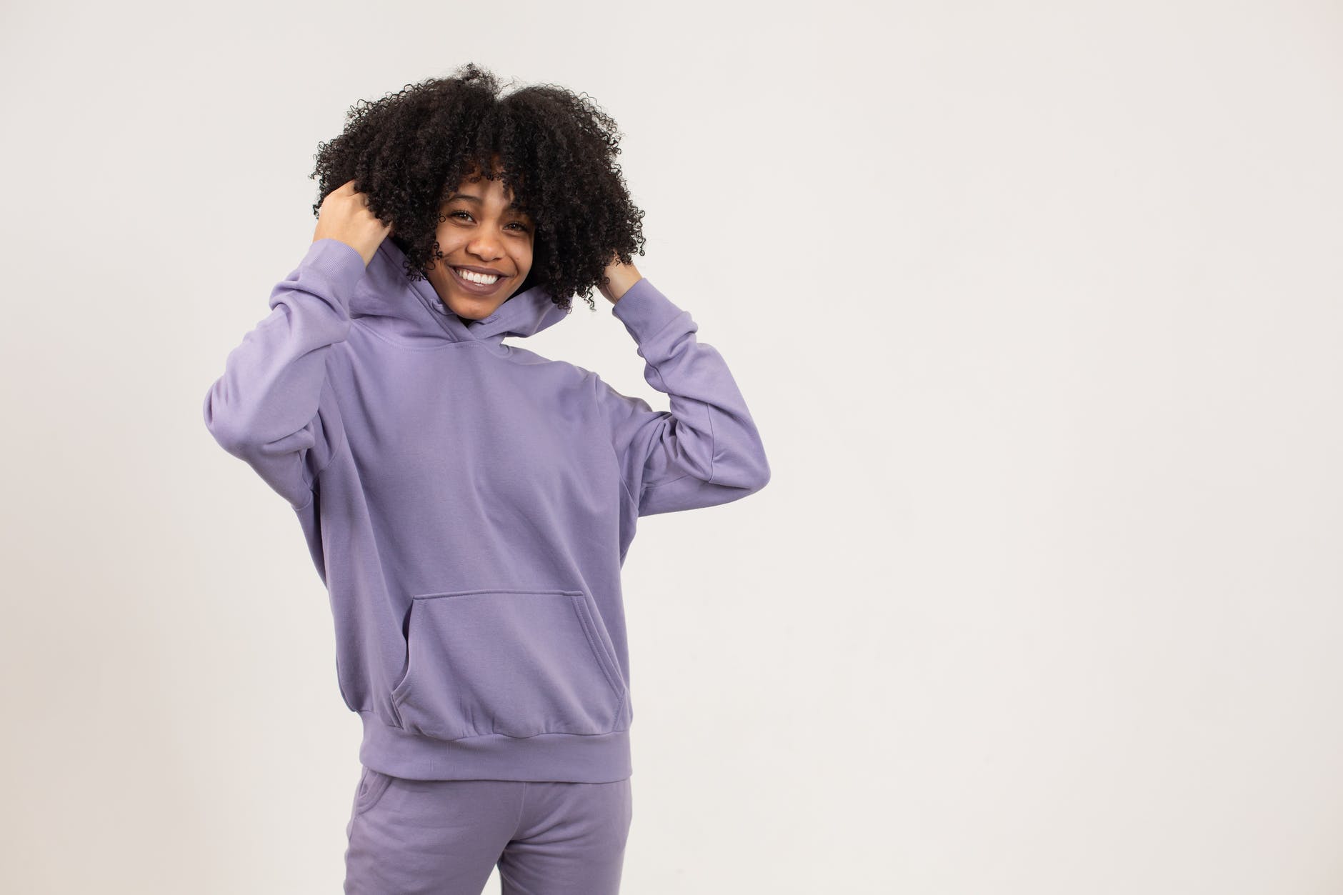 happy black lady wearing hoodie in studio